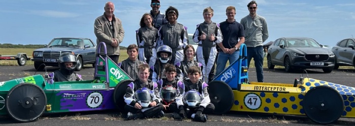 GreenPower engineering and racing team stood next to race cars